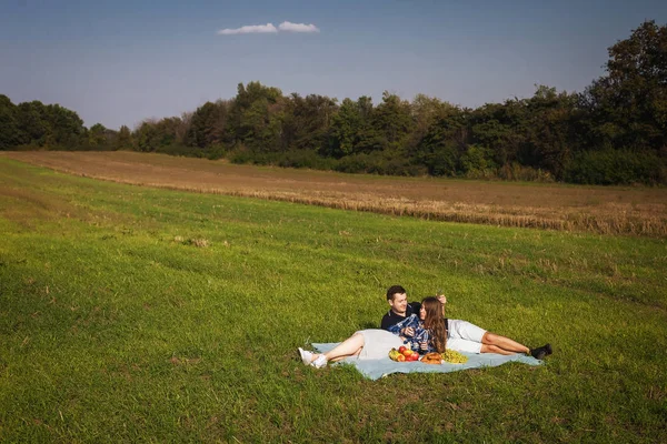 Unga par att ha picknick på gräsmattan — Stockfoto