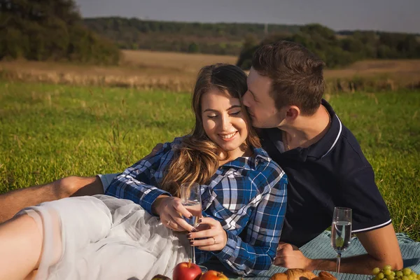 Woman and man having picnic in the field. smell her hair — Stockfoto