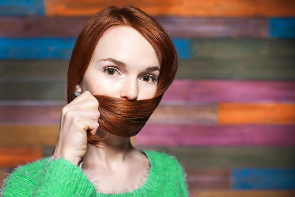 Giovane bella ragazza dai capelli rossi che copre la bocca con i capelli — Foto Stock