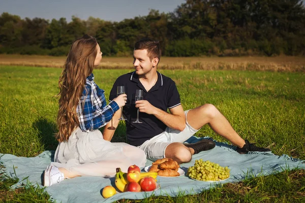 Man och kvinna som dricker vin på en picknick. croissant, banan, vindruvor — Stockfoto