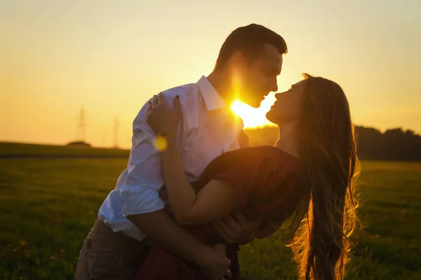 Paar küsst sich bei Sonnenuntergang auf dem Feld — Stockfoto