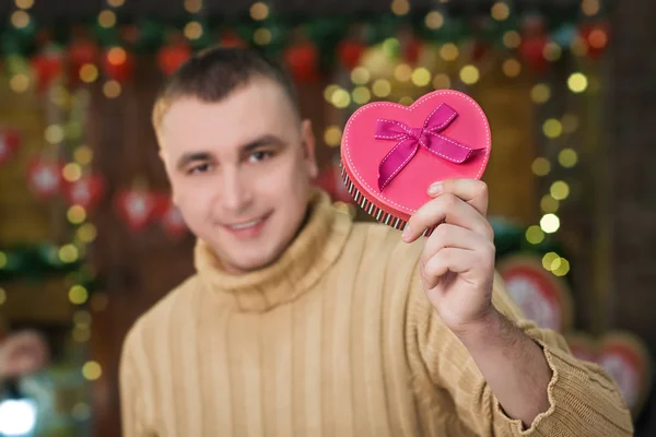 El hombre sostiene la caja en forma de corazón en la mano — Foto de Stock