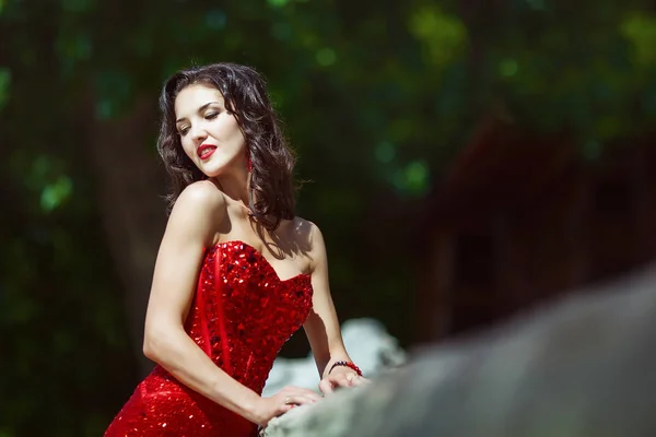 Attractive girl with curly long hair in red dress — Stock Photo, Image