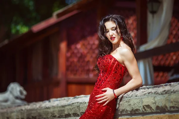 Элегантная леди в красном платье снаружи — стоковое фото