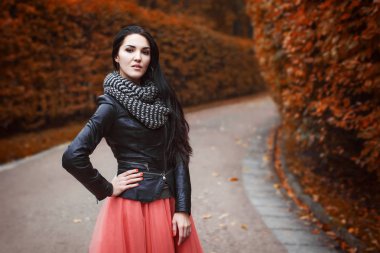 kız siyah deri ceket, pembe etek ve çizgili örme atkı