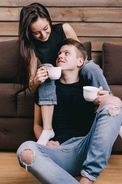 Schöner Kerl mit Mädchen, das daneben sitzt und Kaffee trinkt — Stockfoto