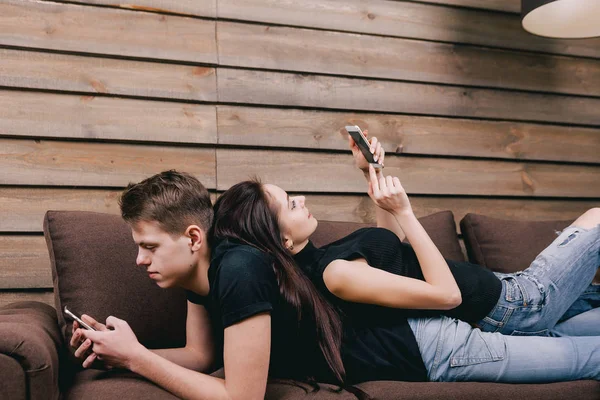 디지털 전화 함께 침대에 누워 있는 젊은 부부 — 스톡 사진