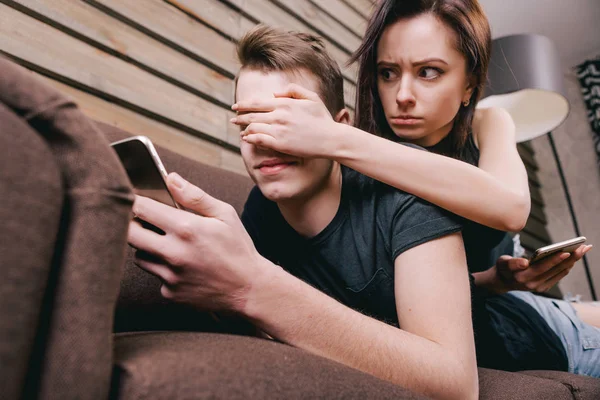 Söt par i sängen med digital telefon i händer — Stockfoto