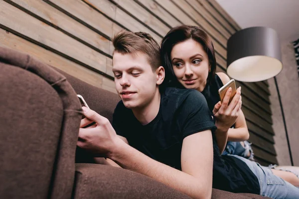 Милая пара в постели со смартфоном в руках — стоковое фото