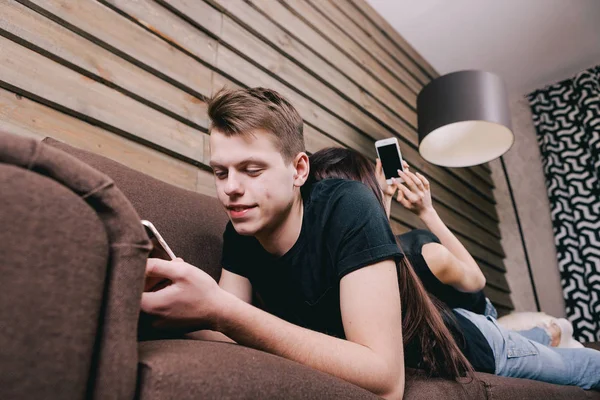 Två vänner i sängen och med smartphone — Stockfoto
