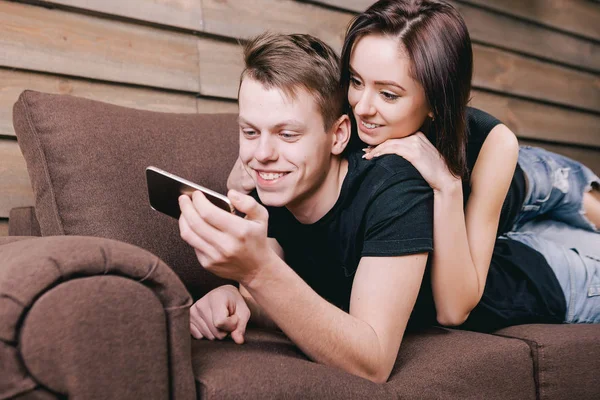 Счастливые влюбленные лежат дома на диване — стоковое фото