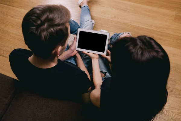 Par sitter på golvet och tittar på Tablet PC-skärmen — Stockfoto