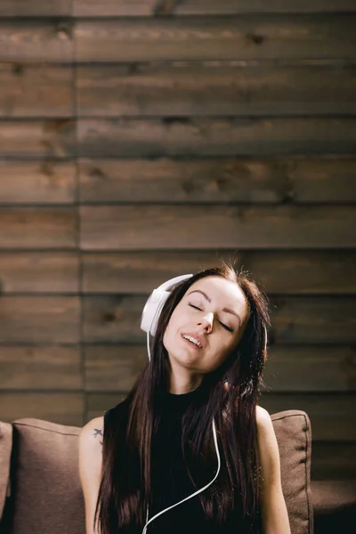Bruneta žena se sluchátky si se zavřenýma očima — Stock fotografie
