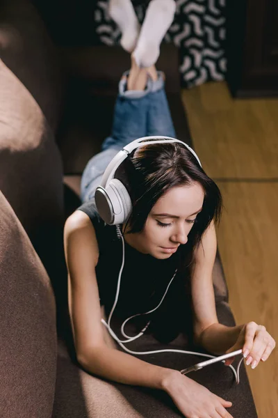Dívka s sluchátka sledování filmu na chytrý telefon — Stock fotografie