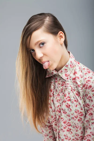Linda chica joven mostrando lengua — Foto de Stock