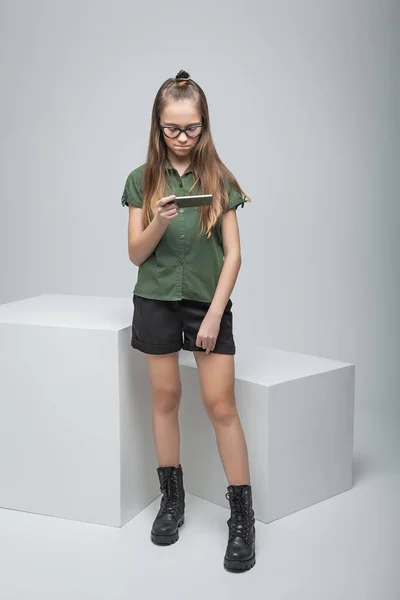 Chica de pie cerca de gran cubo blanco con teléfono — Foto de Stock