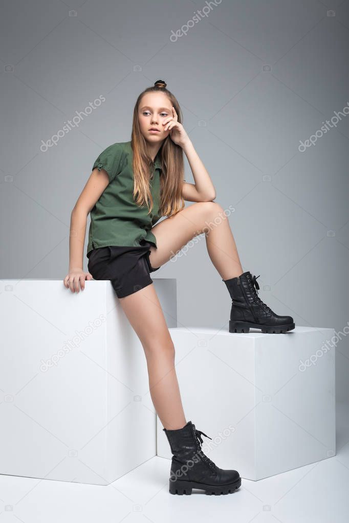 Young beautiful girl sitting on cube