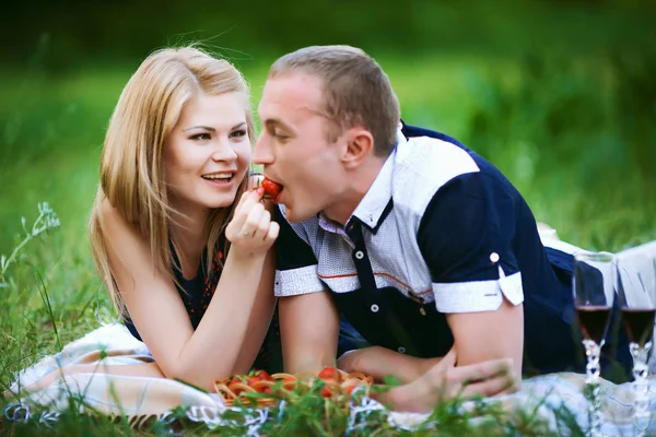 Mädchen füttert Kerl eine Erdbeere — Stockfoto