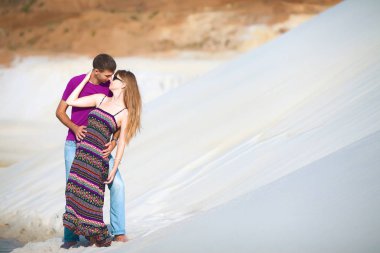 genç adam ve kız sahilde sarılma