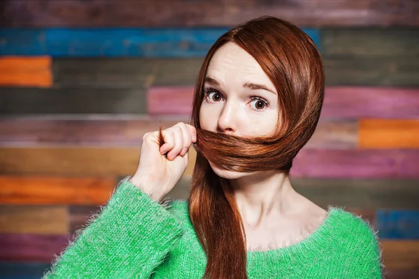 Молода красива руда дівчина покриває рот волоссям — стокове фото