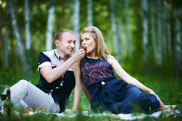 Liefdevolle man voedt een meisje aardbeien — Stockfoto