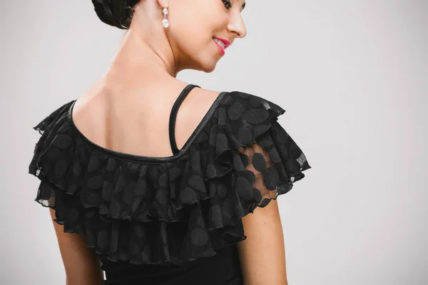 Vrouw in zwarte jurk draaide achteruit — Stockfoto