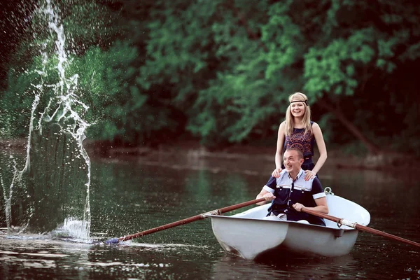 Happy couple rowing and splashing on lake — Stock Photo, Image