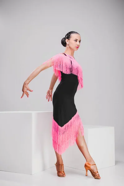 Girl in pink and black dress posing in white studio — Stock Photo, Image