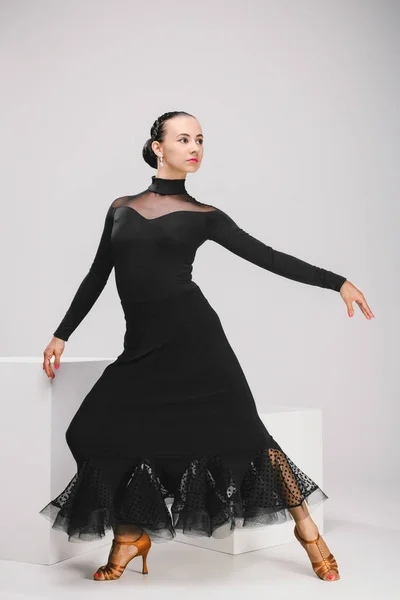 Young woman in black dress dancing in studio — Stock Photo, Image