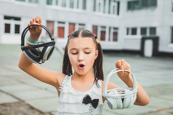 Menina bonita segurando fone de ouvido — Fotografia de Stock