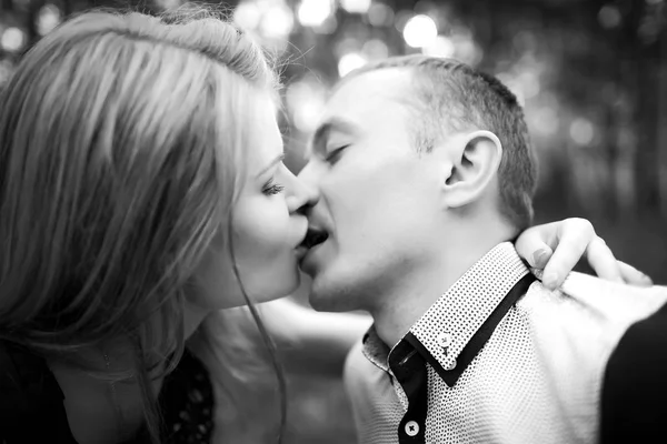 Mladý muž a žena líbat pod širým nebem — Stock fotografie