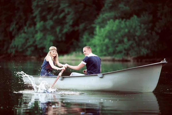 Girl and guy rowing on lake — Stock Photo, Image