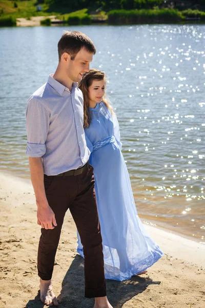 Schönes Paar zu Fuß am Strand entlang — Stockfoto