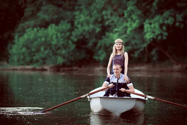 Cute girl staying near rowing guy on boat — Stock Photo, Image