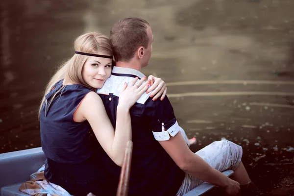 Facet i dziewczyna siedzi na skraju łódź — Zdjęcie stockowe