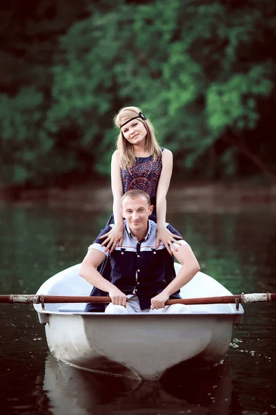 Сладкая девушка, остающаяся рядом с сидящим парнем на лодке — стоковое фото