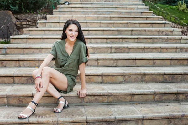 Fiatal, vonzó nő ül a kő lépcsők — Stock Fotó
