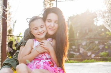 Anne ve kızı closen gözlerine güneş ışığı ile sarılma