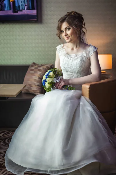 Женщина со свадебным букетом сидит на стуле — стоковое фото