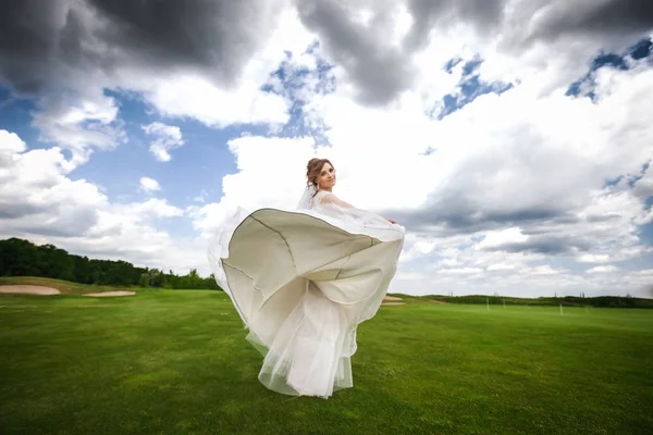 Красивая невеста танцует и улыбается в красивой природе — стоковое фото