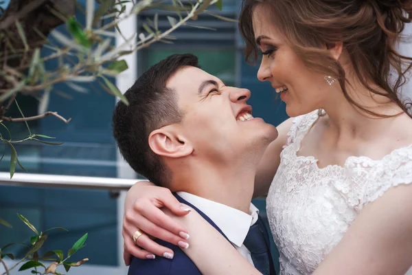 Newlywed para przytulanie i uśmiechając się w pobliżu drzewa w luksusowych restauracji — Zdjęcie stockowe