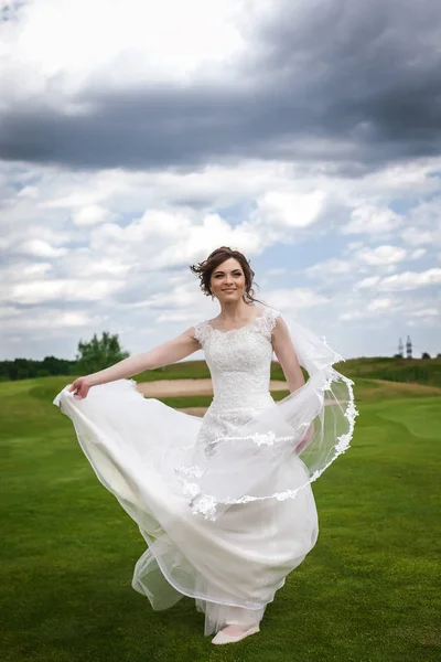 Привлекательная невеста работает на зеленом поле для гольфа — стоковое фото