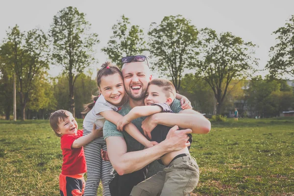 Lycklig familj som roar sig i parken — Stockfoto