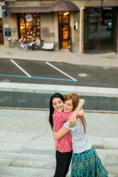 Dvě sestry objímání na ulici — Stock fotografie