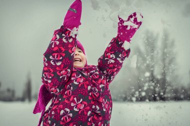 Kış ormandaki kar taneleri ile oynayan kız