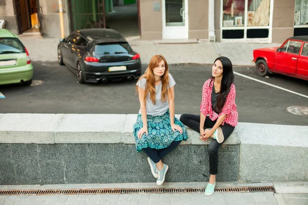 Zwei Mädchen sitzen in der Nähe eines Parkplatzes — Stockfoto