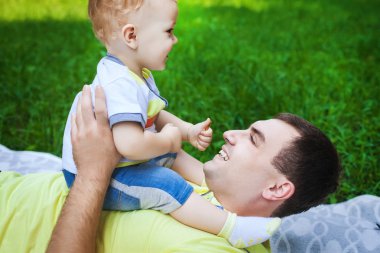 neşeli baba ve oğlu çimenlerin üzerinde