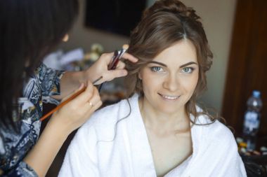 Çekici genç gelin düğünde ev, yapım makyaj için hazırlanıyor