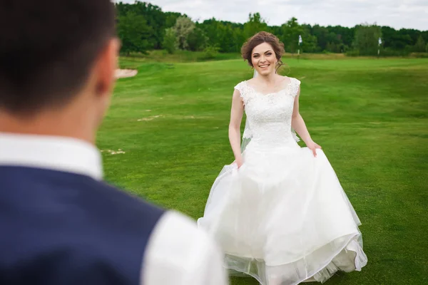 Молодая невеста бежит встречать жениха на лугу — стоковое фото