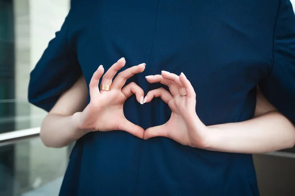 Bruid maken van hart met vingers op bruidsparen terug — Stockfoto